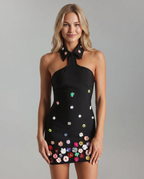 Mini dress elegante con scollatura halter e decorazioni floreali.